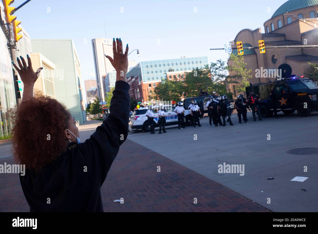 Protester Alisha Watters, 28, of Columbus, Ohio raises her hands and arms to show the police that she is not a threat during the demonstration.Five days after the death of George Floyd at the hands of Minneapolis Police Officer Derek Chauvin Columbus, Ohio declared a state of emergency and imposed a curfew from 10pm to 6am to deal with the large scale protests happening in the city. The Ohio National Guard were called in at 3pm to help quell the protests and stop any rioting. National Guard and Riot officers pushed protesters north on High St. tear gassing and arresting protesters. Stock Photo