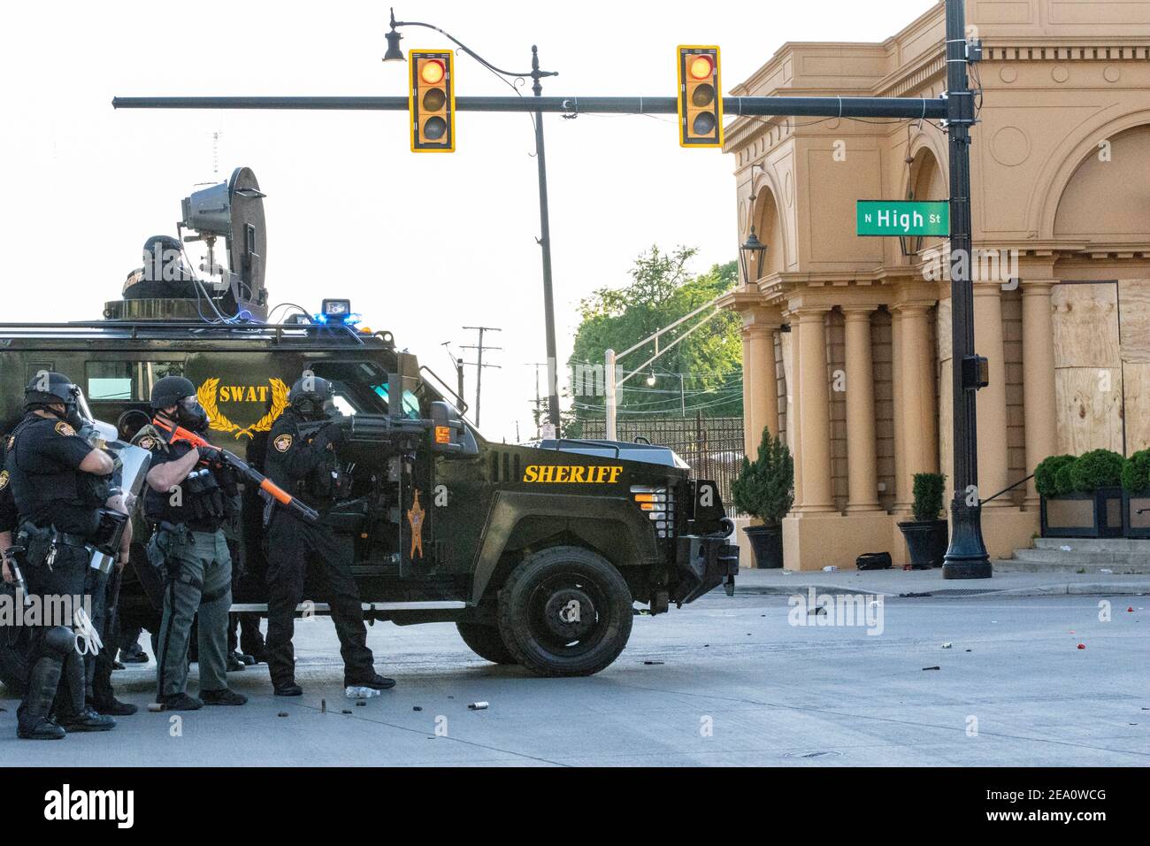 Ohio SWAT officer aims less-lethal launcher at the protesters on North High St while taking cover behind an armoured SWAT vehicle during the demonstration.Five days after the death of George Floyd at the hands of Minneapolis Police Officer Derek Chauvin Columbus, Ohio declared a state of emergency and imposed a curfew from 10pm to 6am to deal with the large scale protests happening in the city. The Ohio National Guard were called in at 3pm to help quell the protests and stop any rioting. National Guard and Riot officers pushed protesters north on High St. tear gassing and arresting protesters. Stock Photo