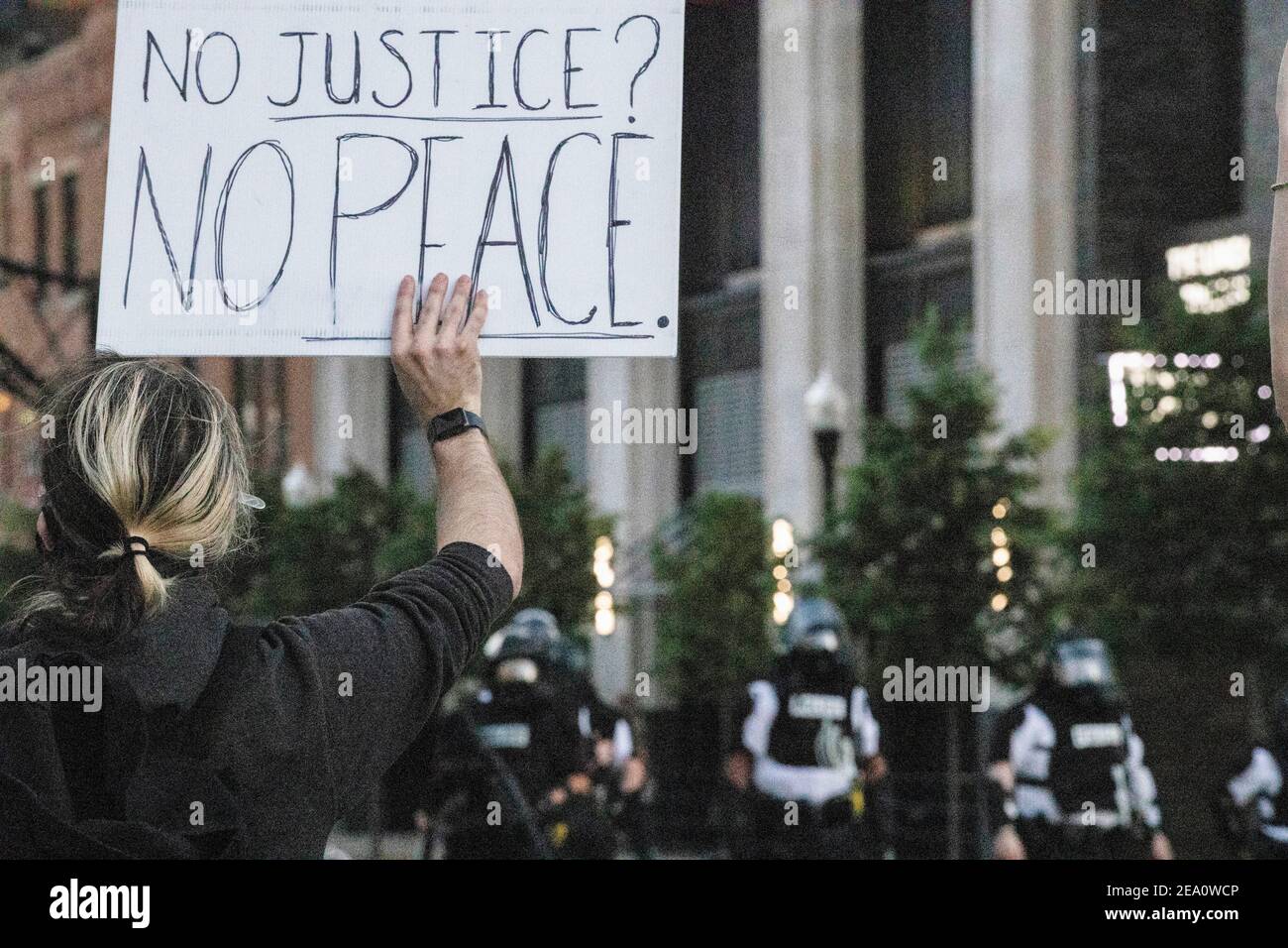 A protester holds a placard that says No Justice? No Peace during the demonstration.Five days after the death of George Floyd at the hands of Minneapolis Police Officer Derek Chauvin Columbus, Ohio declared a state of emergency and imposed a curfew from 10pm to 6am to deal with the large scale protests happening in the city. The Ohio National Guard were called in at 3pm to help quell the protests and stop any rioting. National Guard and Riot officers pushed protesters north on High St. tear gassing and arresting protesters. Stock Photo