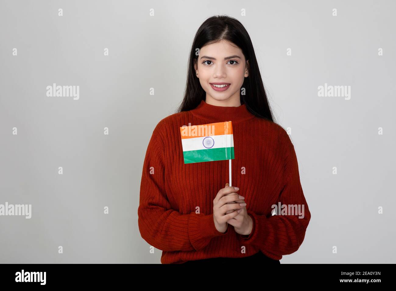 Portrait of a young beautiful female holding the Indian flag, tricolour on display by pretty woman to show national pride. Stock Photo