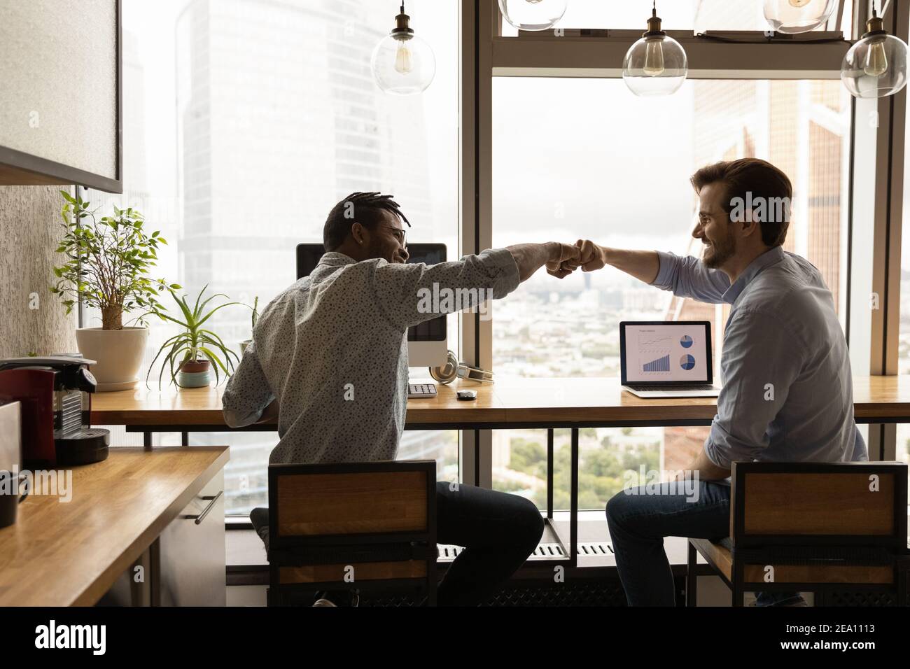 Two workers international team members share success help one another Stock Photo
