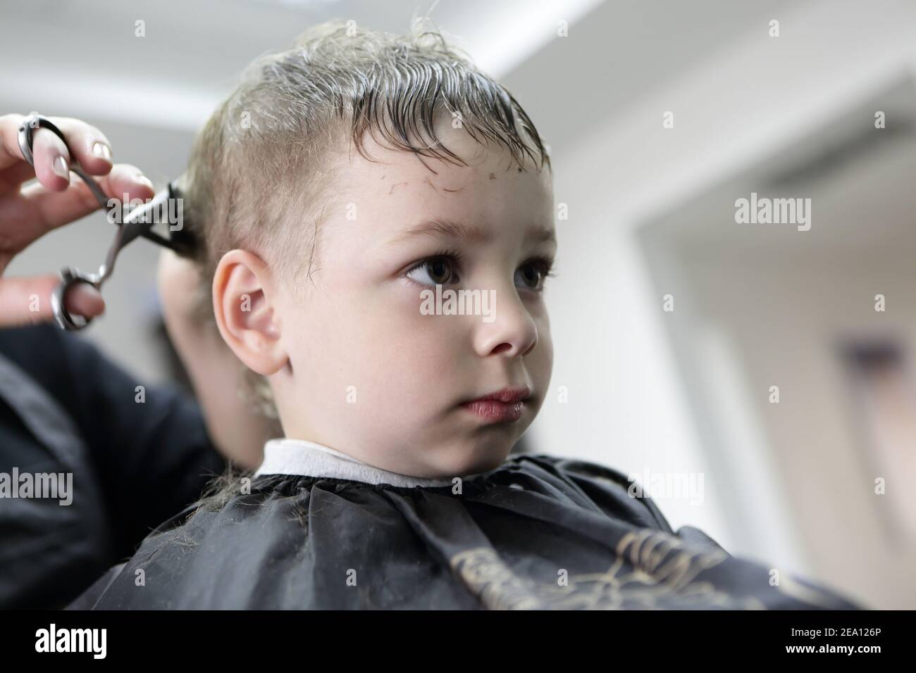Barber cutting hair of a child at the Stock Photo Alamy