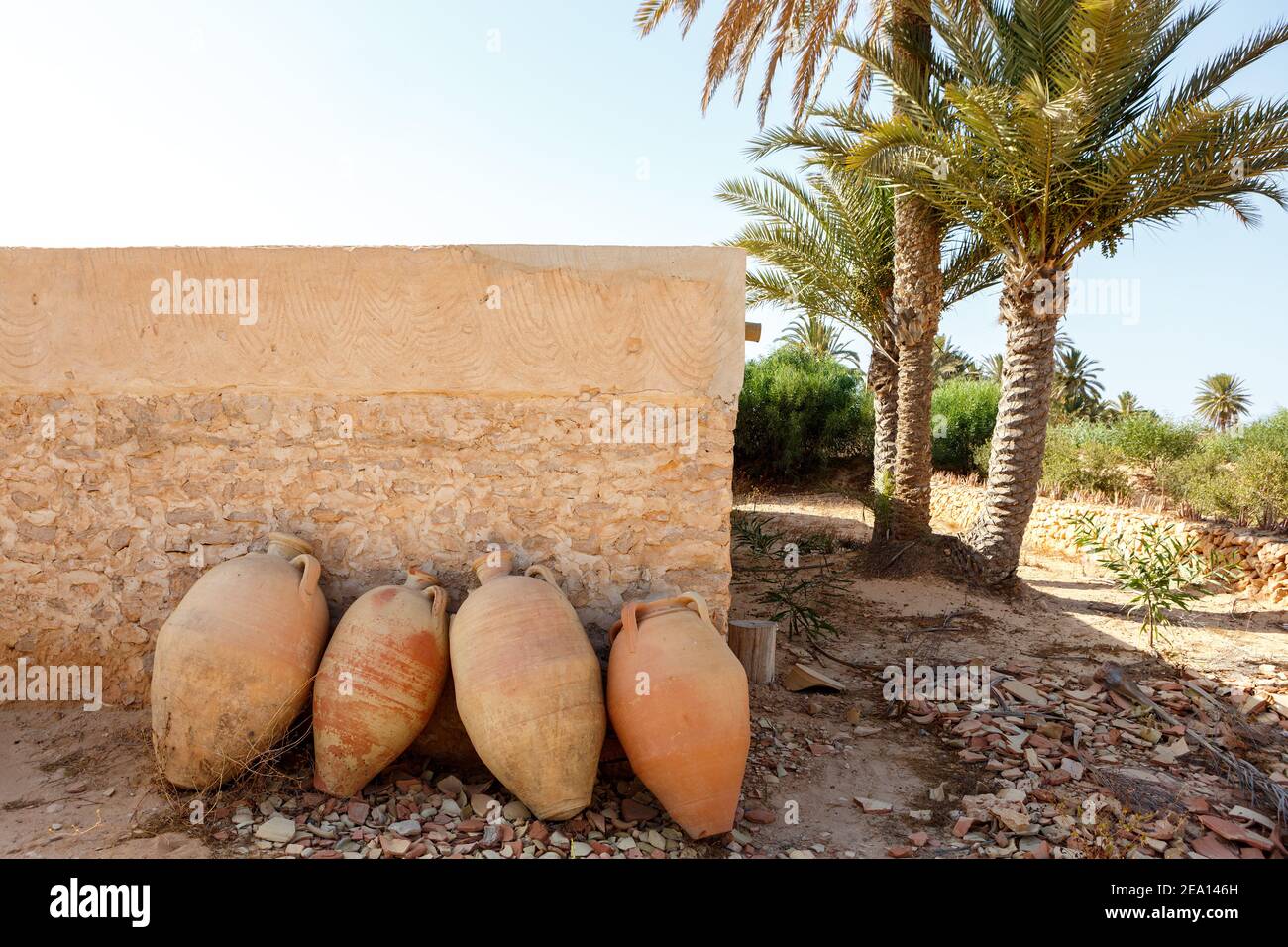 Old earthenware jars against the wall in the shade Stock Photo