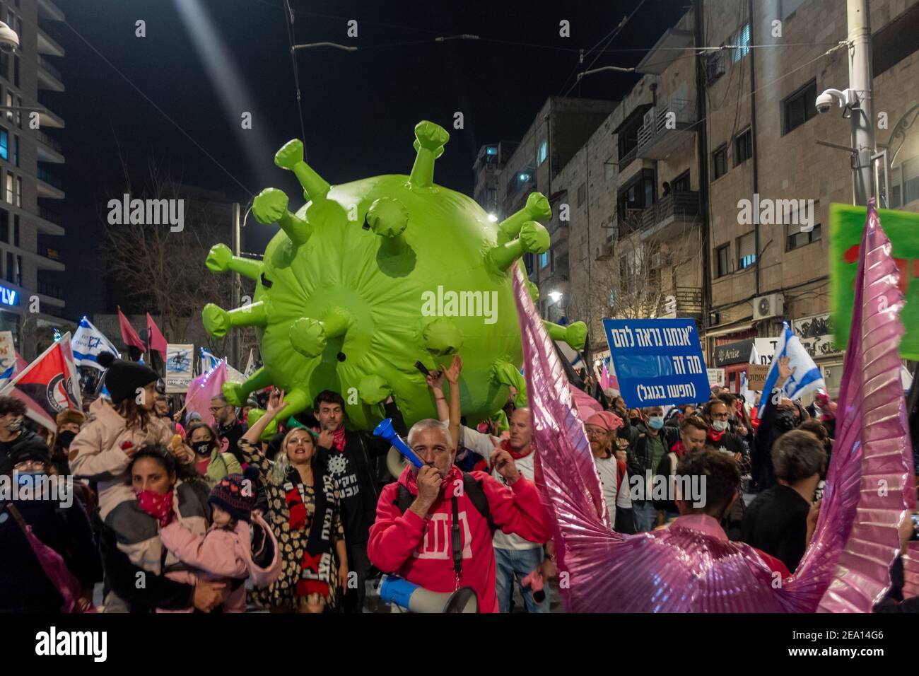 Protesters carry a giant mock-up of a coronavirus as they march through downtown Jerusalem on their way to the prime minister's official residence during a demonstration calling for Benjamin Netanyahu’s resignation citing his government's handling of the coronavirus pandemic and ongoing legal troubles in Jerusalem, Israel. Stock Photo