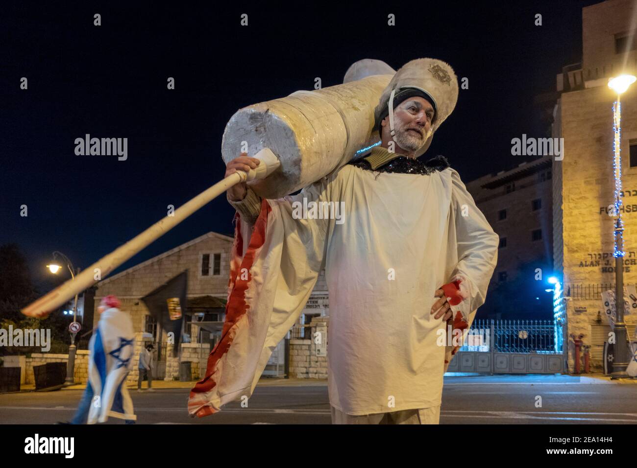 An anti vaccine activist holds a giant syringe during a demonstration calling for Benjamin Netanyahu’s resignation citing his government's handling of the coronavirus pandemic and ongoing legal troubles in Jerusalem, Israel. Stock Photo