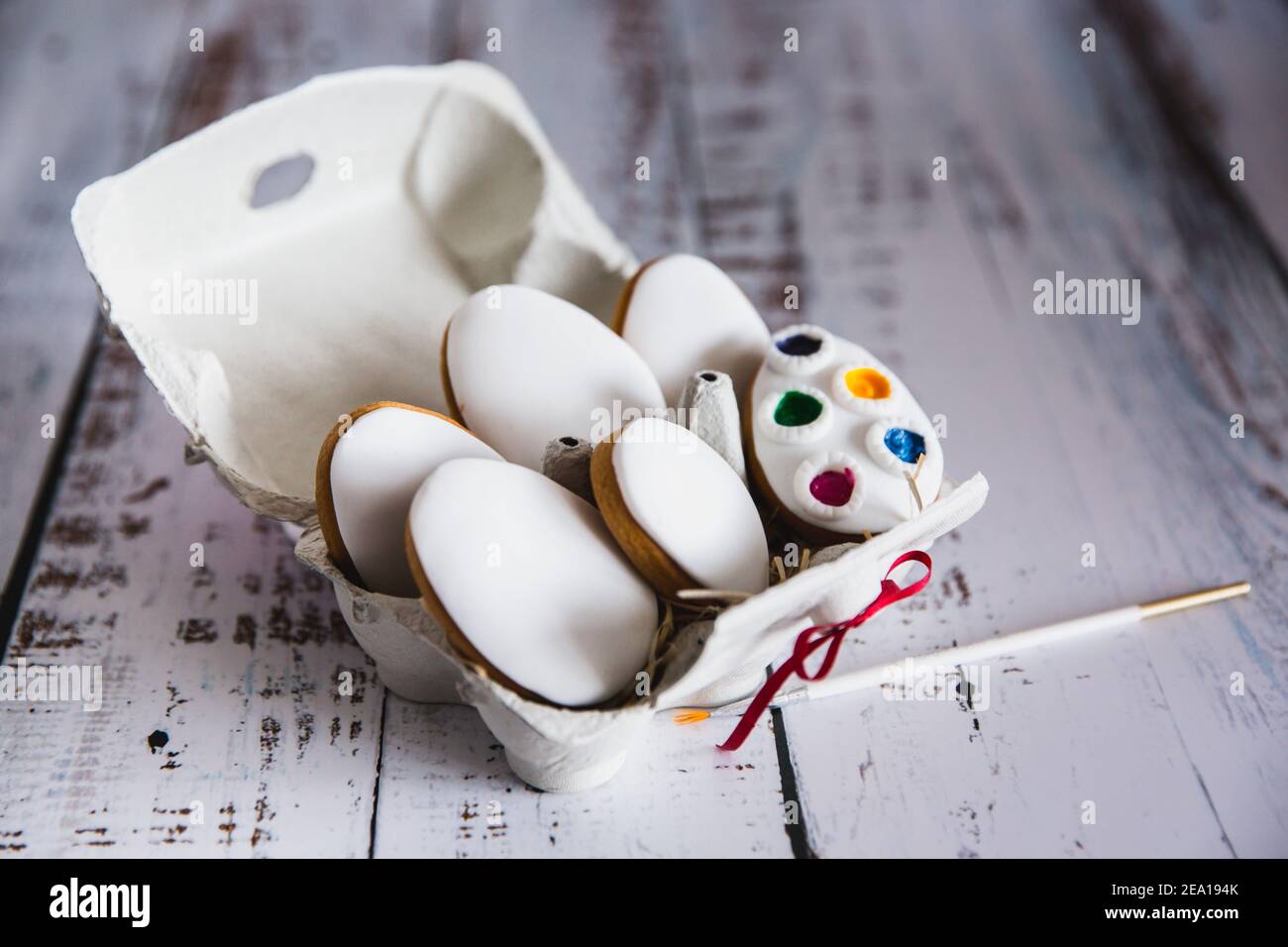 Easter cookies eggs with food coloring in a paper egg holder on white ...