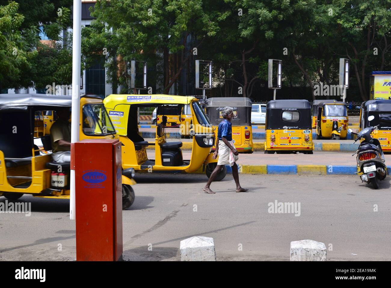 Madurai, Tamil Nadu, India - January, 2017: Auto rickshaws parked on parking lot in front of Madurai Junction railway station. Yellow tuk-tuk taxi Stock Photo