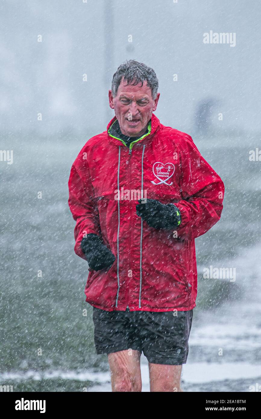 Wimbledon London Uk 7 February 21 A Jogger Runs During A Snow Shower On Wimbledon Common As Storm Darcy Hits The Uk This Morning With Freezing Temperatures The Met Office Has Issued