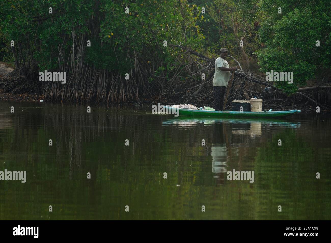 Sinhalese man fishing on a river in a boat Stock Photo