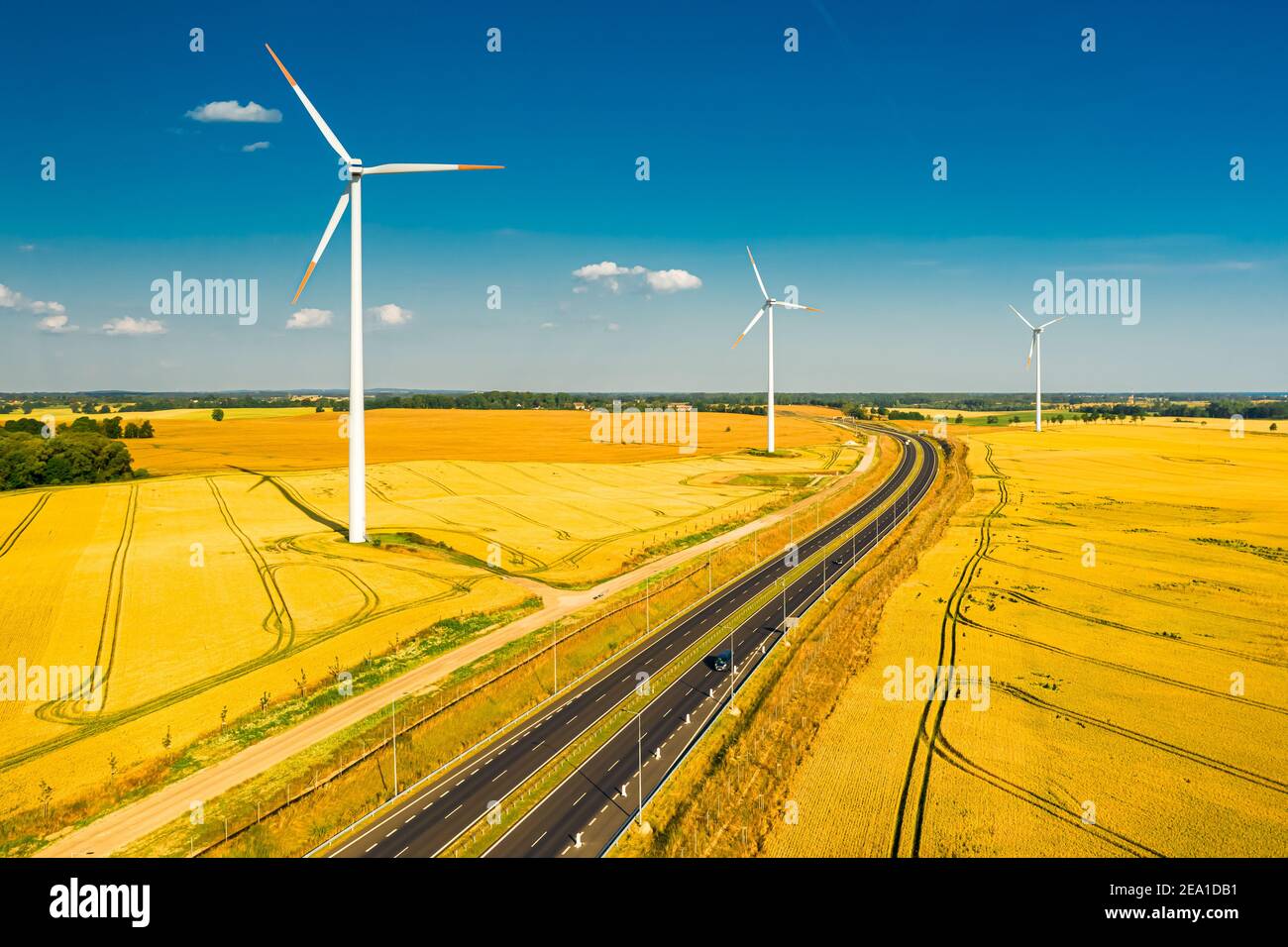 Wind turbines and golden field near highway, aerial view of Poland ...