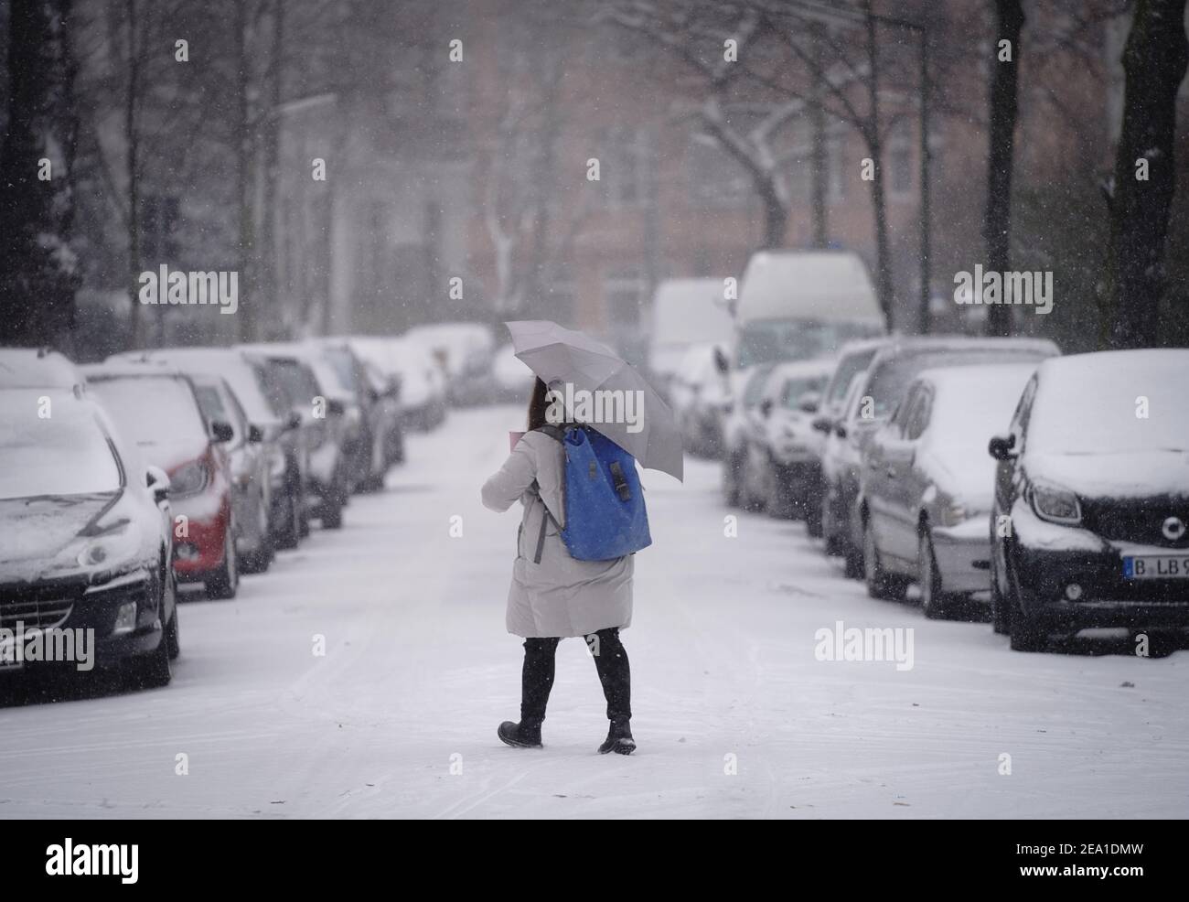 Berlin, Germany. 07th Feb, 2021. A passer-by walks across a street in Berlin-Friedenau in the thick snow. Credit: Kay Nietfeld/dpa/Alamy Live News Stock Photo