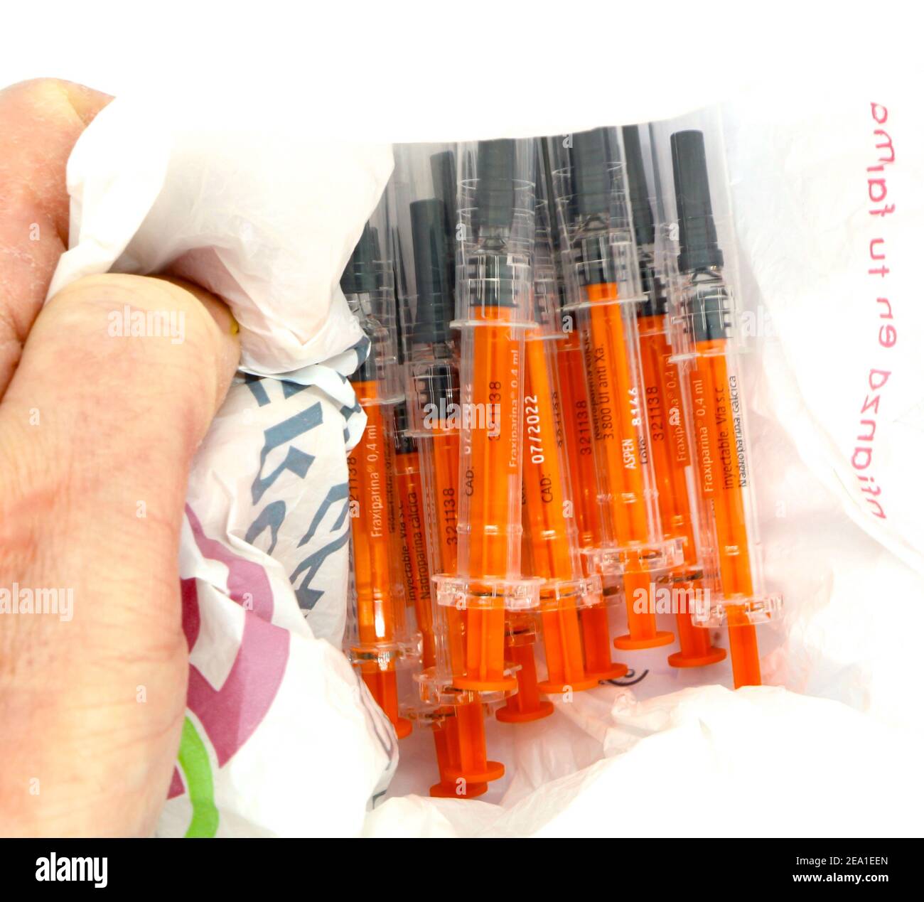 Plastic bag held open full of Transparent black and orange used plastic