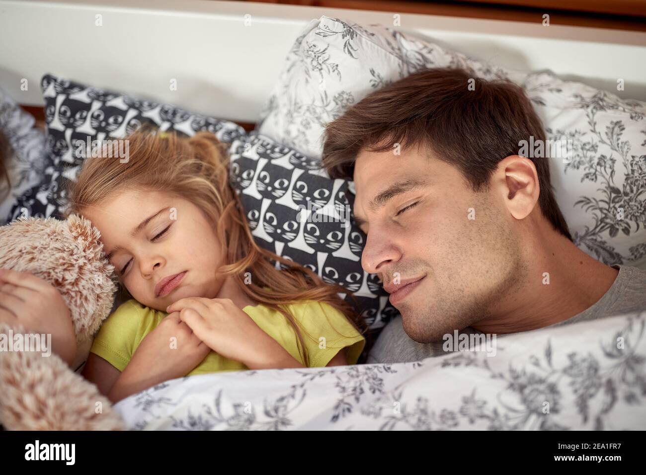 Dad and little daughter in a sleep on a beautiful morning at home ...