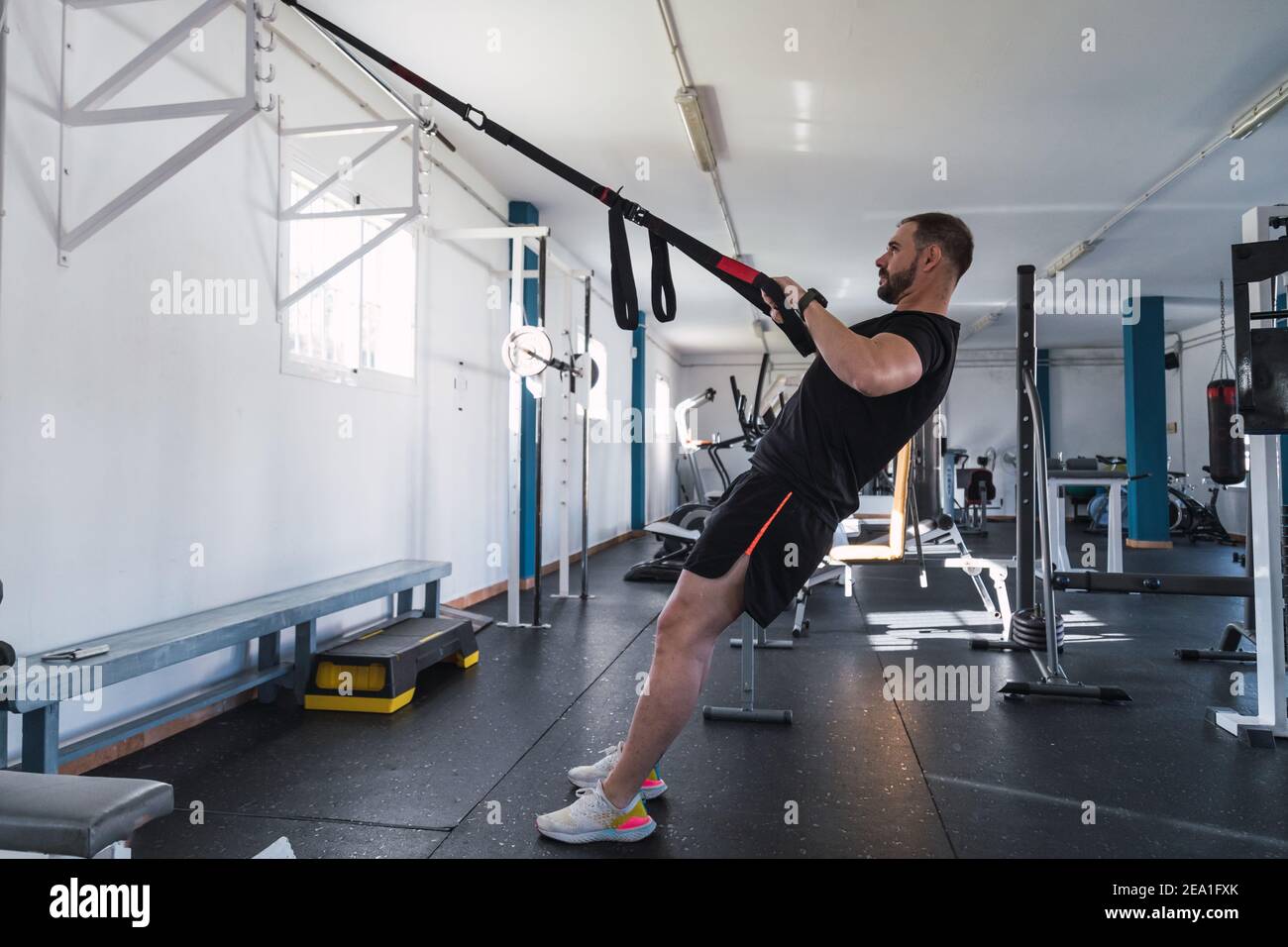 Young man doing TRX exercises at the gym. TRX training Stock Photo