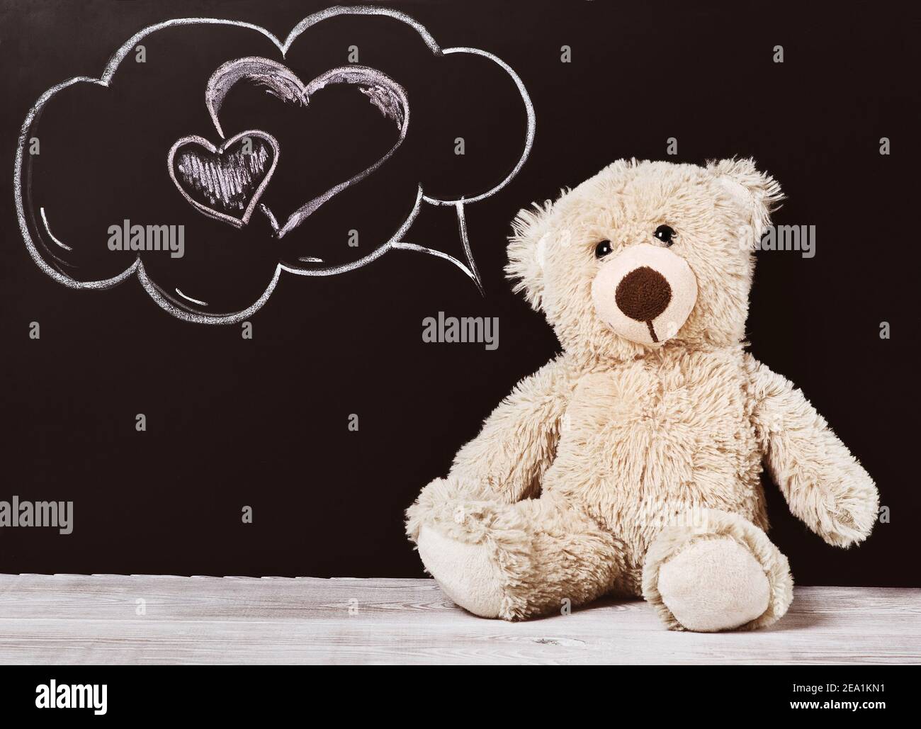 Teddy bear near blackboard. Valentines Day background. chalk heart. Stock Photo