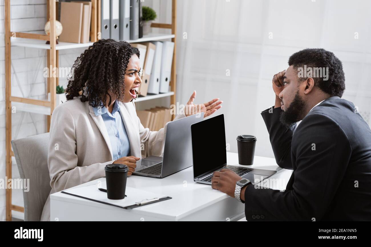 Angry African American woman having fight with her collague at company office, copy space Stock Photo