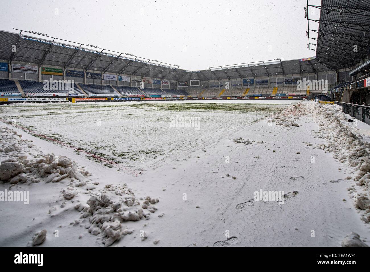 07 February 2021, North Rhine-Westphalia, Paderborn: Football: 2. Bundesliga, SC Paderborn 07 - 1. FC Heidenheim, Matchday 20, at Benteler-Arena. View into the empty stadium with snow-covered turf. Helpers had been clearing the pitch of snow since early morning. Due to the heavy snowfall, the match was nevertheless cancelled shortly before kick-off. Photo: David Inderlied/dpa - IMPORTANT NOTE: In accordance with the regulations of the DFL Deutsche Fußball Liga and/or the DFB Deutscher Fußball-Bund, it is prohibited to use or have used photographs taken in the stadium and/or of the match in the Stock Photo