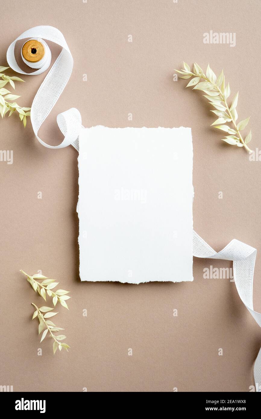 blank-paper-card-mockup-silk-ribbon-and-dried-flowers-on-pastel-beige