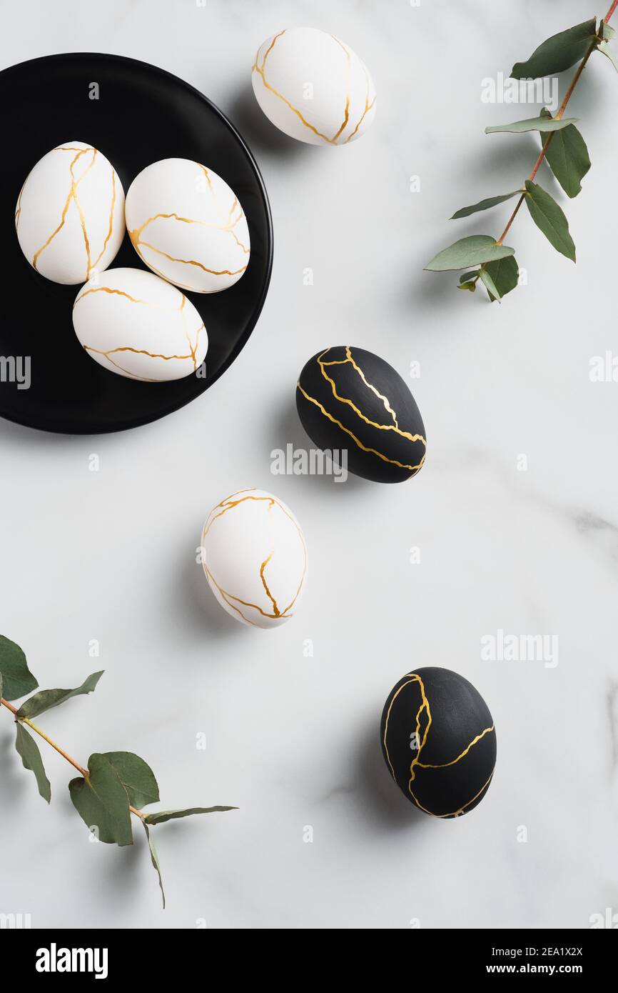 Modern style Easter eggs decorated with golden metal on marble ...