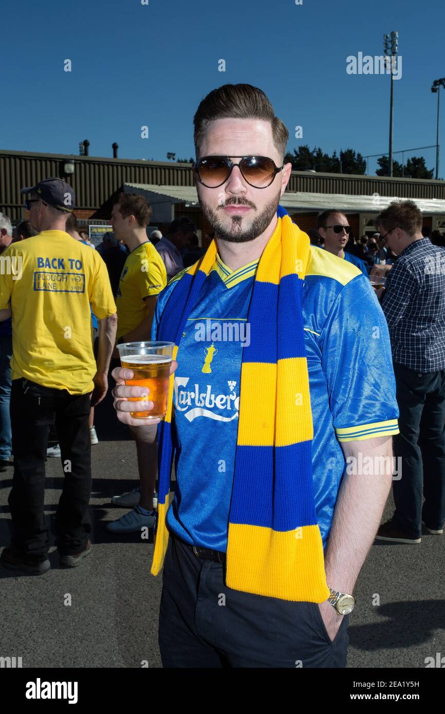 Football supporter holding beer outside AFC Wimbledon football stadion, England. Stock Photo