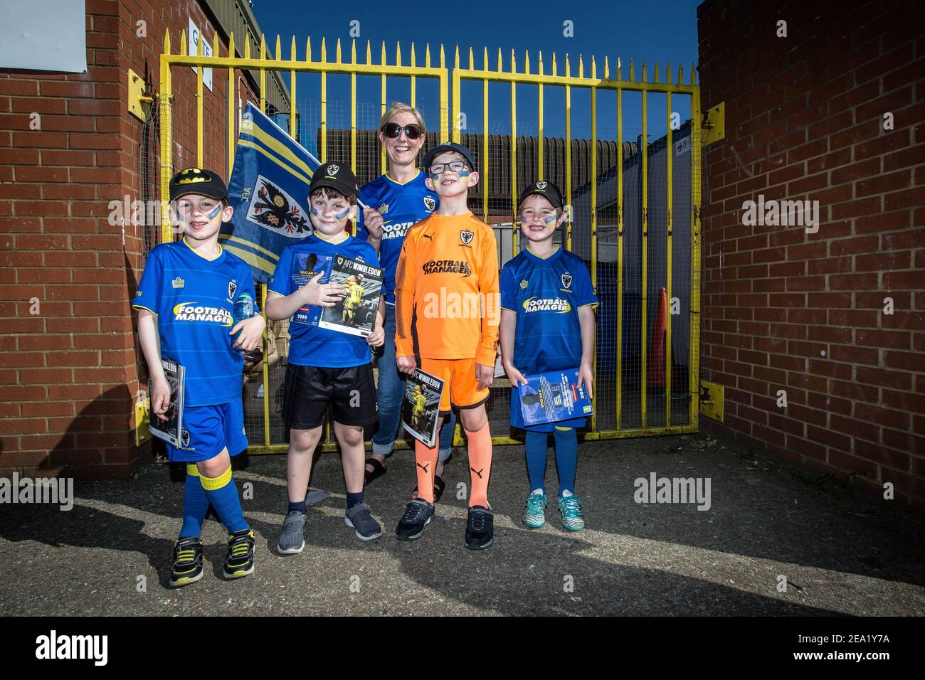 Young football fans with mother at AFC Wimbledon football club, England Stock Photo