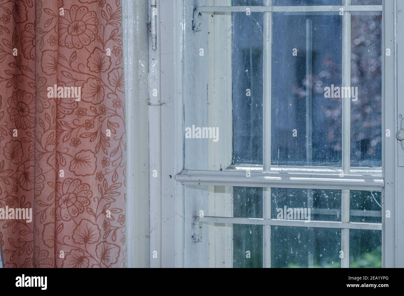 window with red curtain in old house Stock Photo