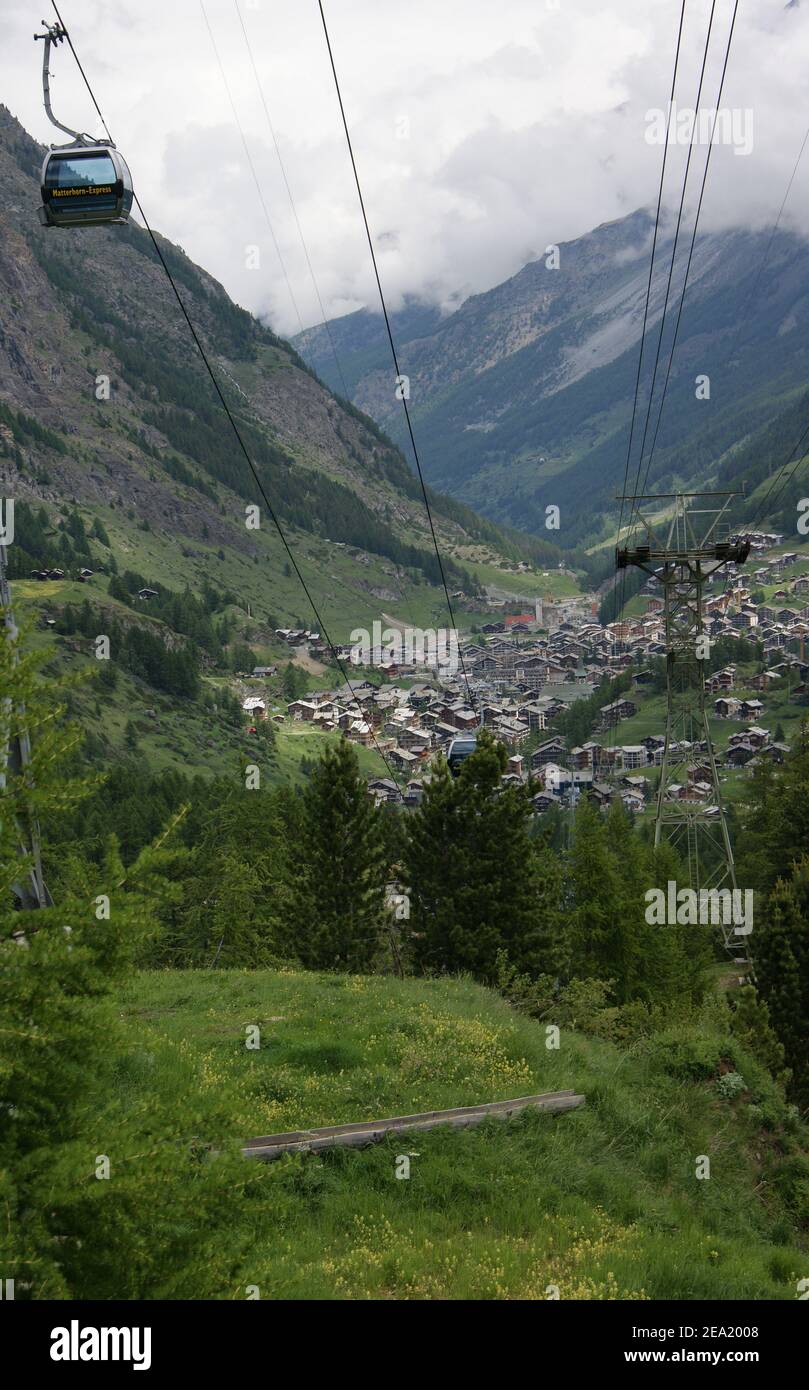 Zermatt viewed from a gondola on the Matterhorn Express as it glides over small forests and wildflower meadows. Stock Photo