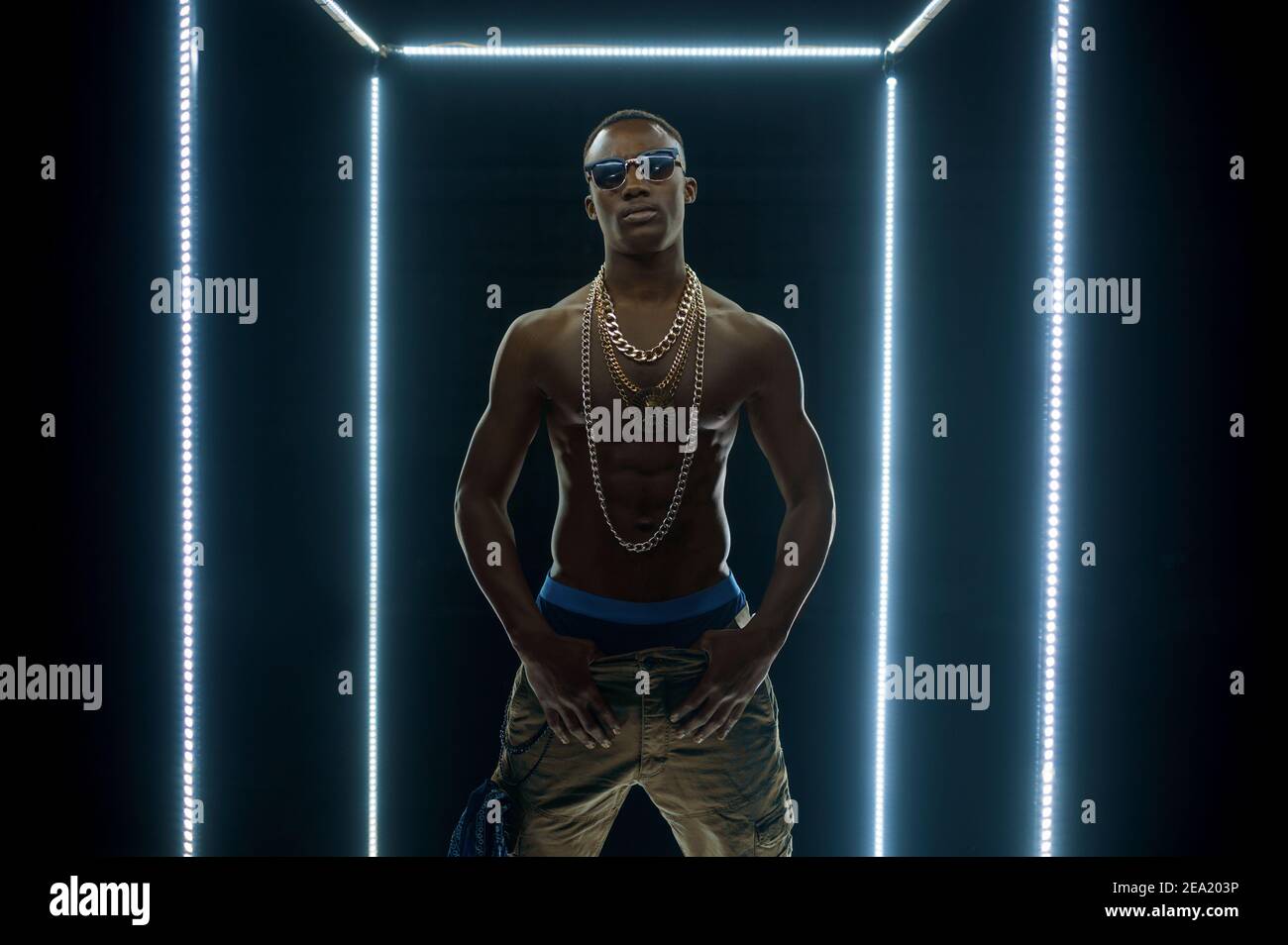 Rapper in gold chains dancing in illuminated cube Stock Photo - Alamy