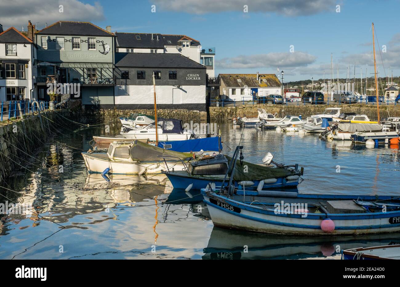 Custom House Quay and Chain Locker of Falmouth, viewed across the water and boats at high tide with reflections in the sunshine Stock Photo