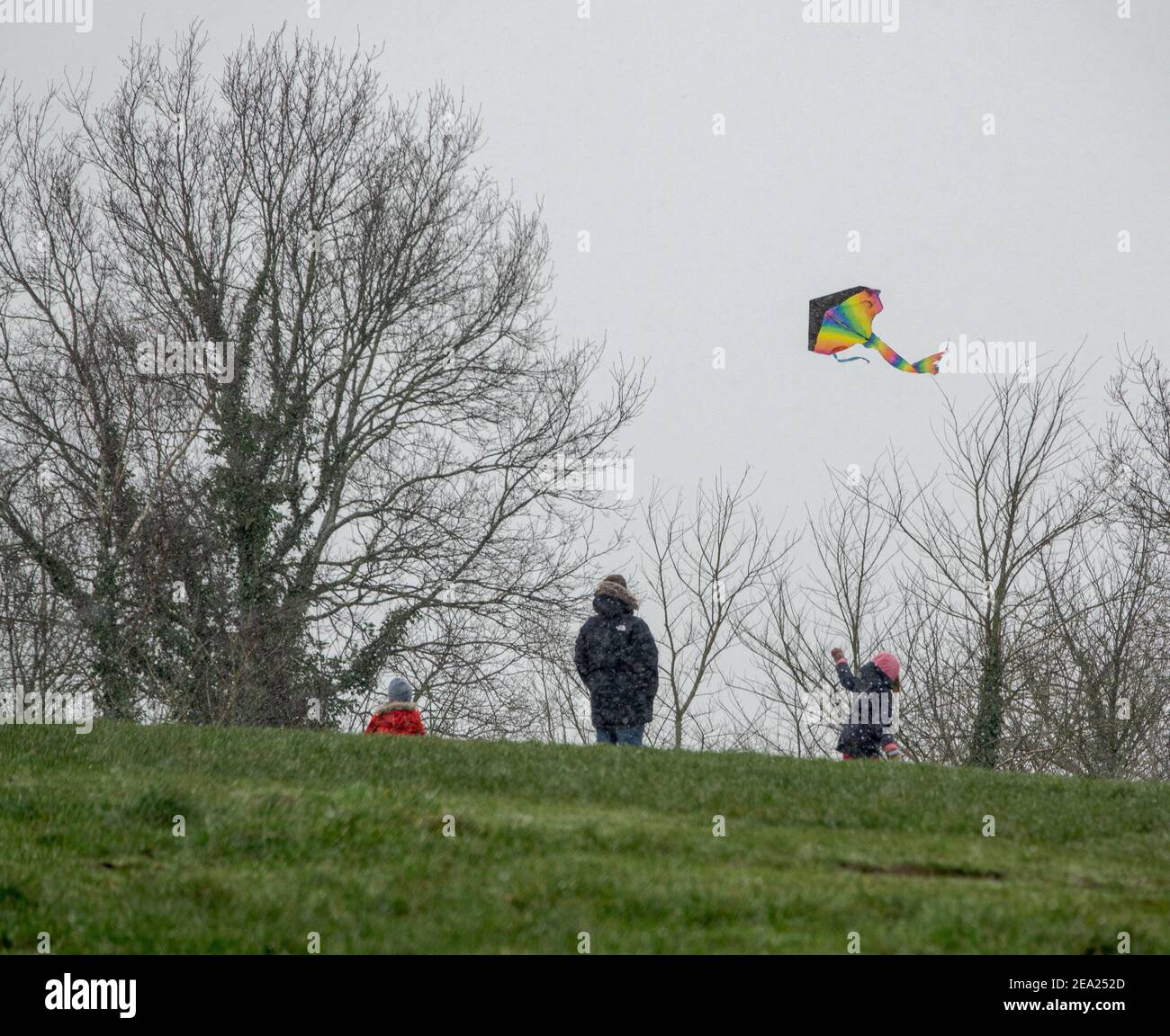 A girl flies a kite on Parliament Hill, Hampstead Heath, with her