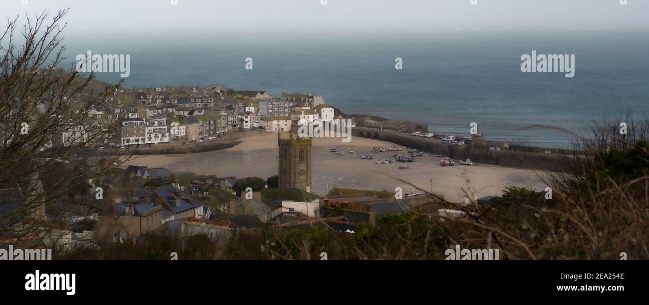 View down from the hill above of St. Ives town showing houses, unique church and bay beyond. Very quiet due to the lockdown caused by the pandemic Stock Photo