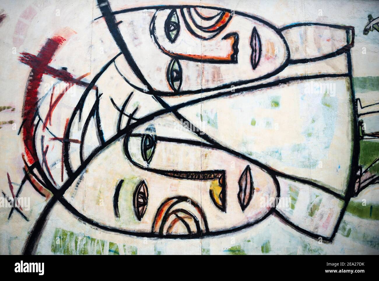 Graffiti Joint Venture with two faces, artist Margaret Hunter, East Side Gallery, Mauergalerie, Berlin, Germany Stock Photo