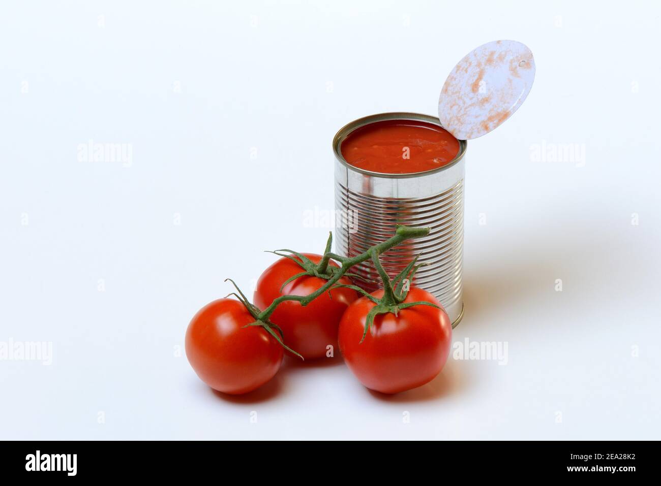 Opened tin of canned tomatoes and ripe tomatoes Stock Photo