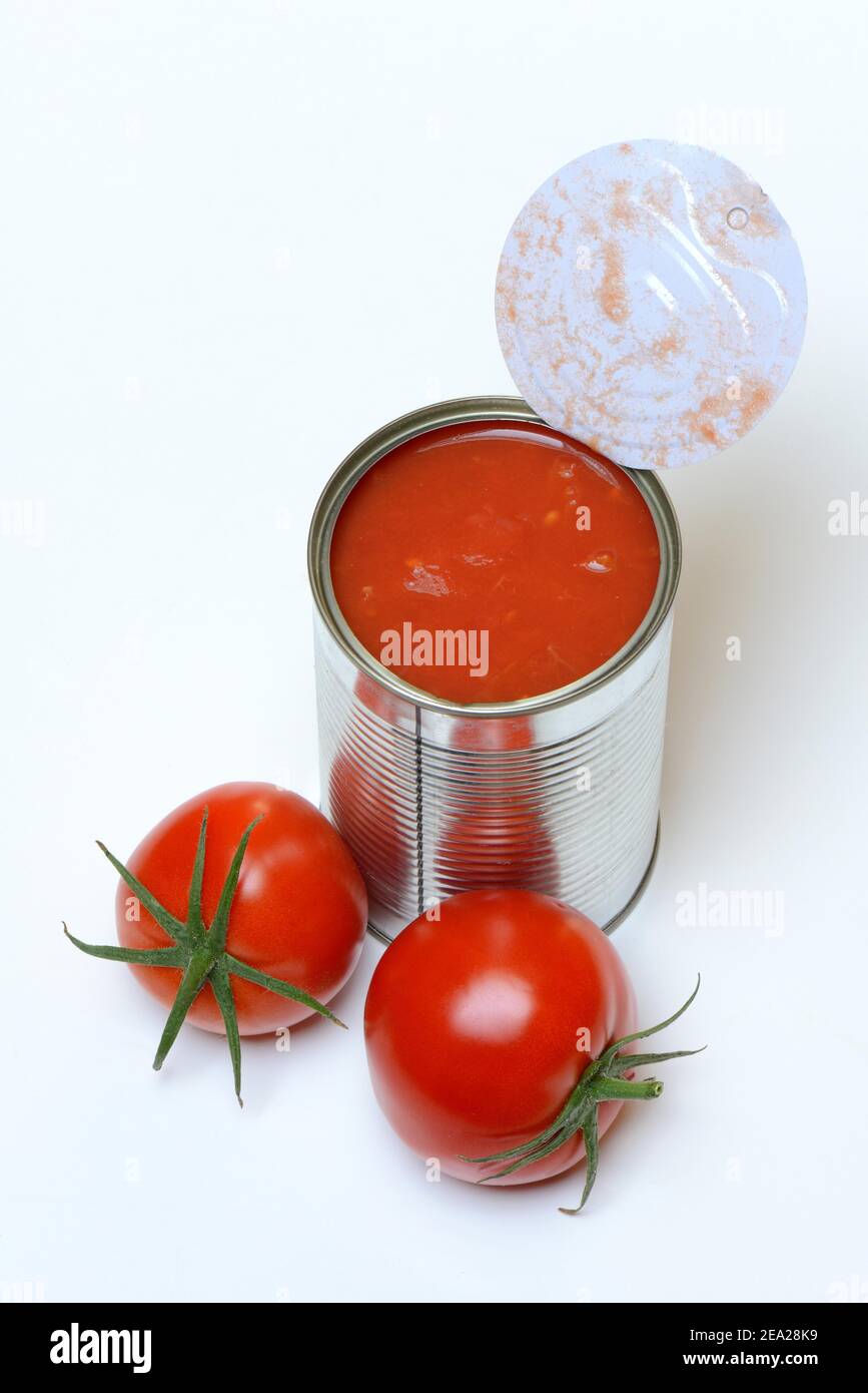 Opened tin of canned tomatoes and ripe tomatoes Stock Photo