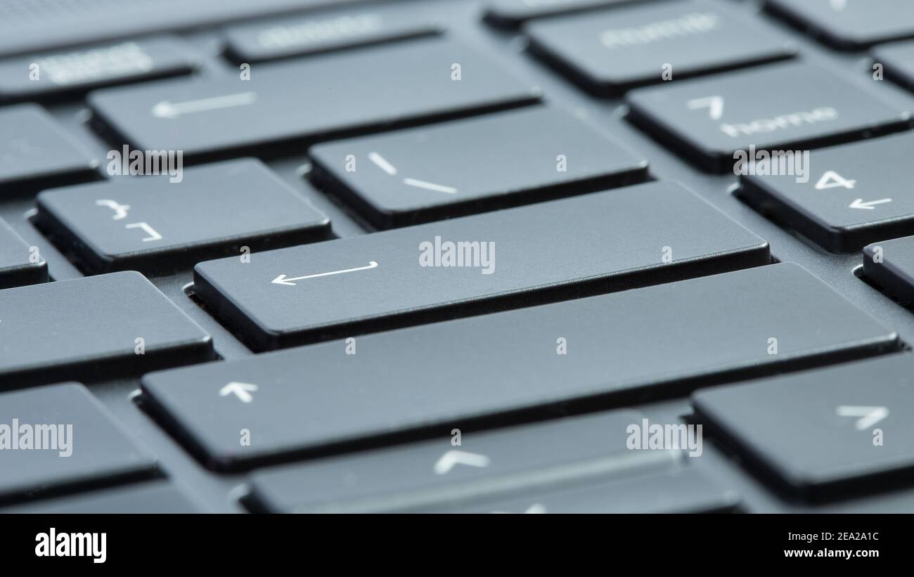 Gray laptop keyboard macro close-up. Selective focus on enter buttons. Stock Photo