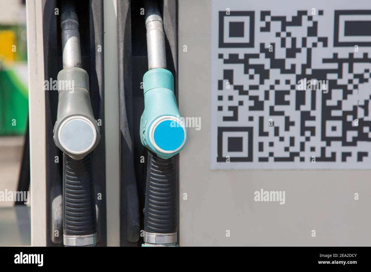 Petrol pump filling nozzles and QR code are on gas station. Concept
