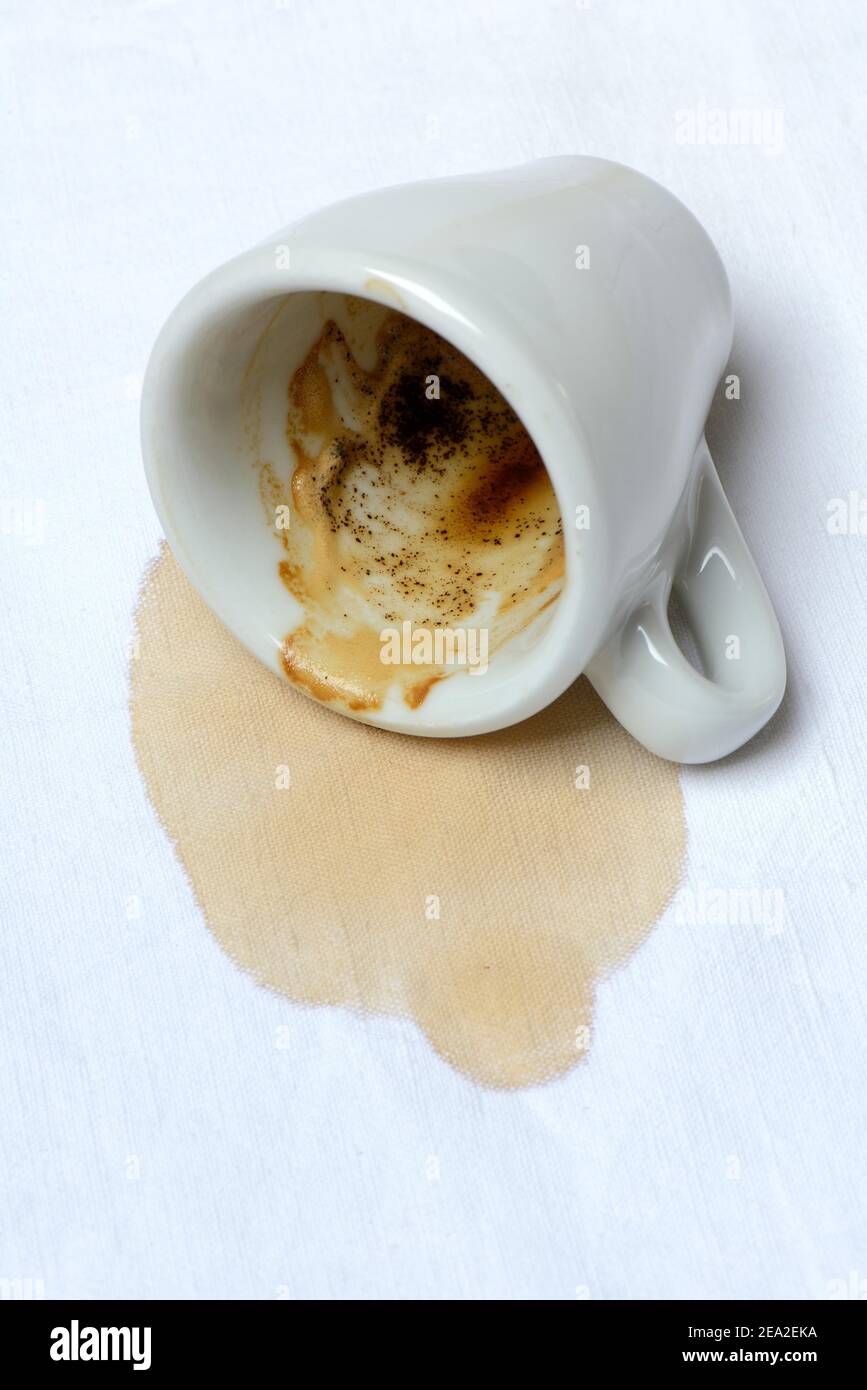 Coffee stain on tablecloth and fallen cup, spilled Stock Photo