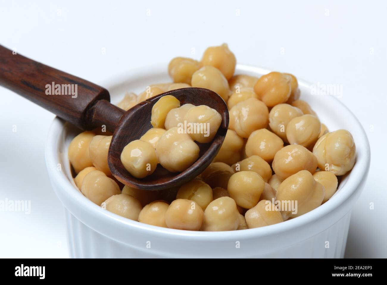 Chickpeas ( Cicer arietinum) in bowl with wooden spoon Stock Photo