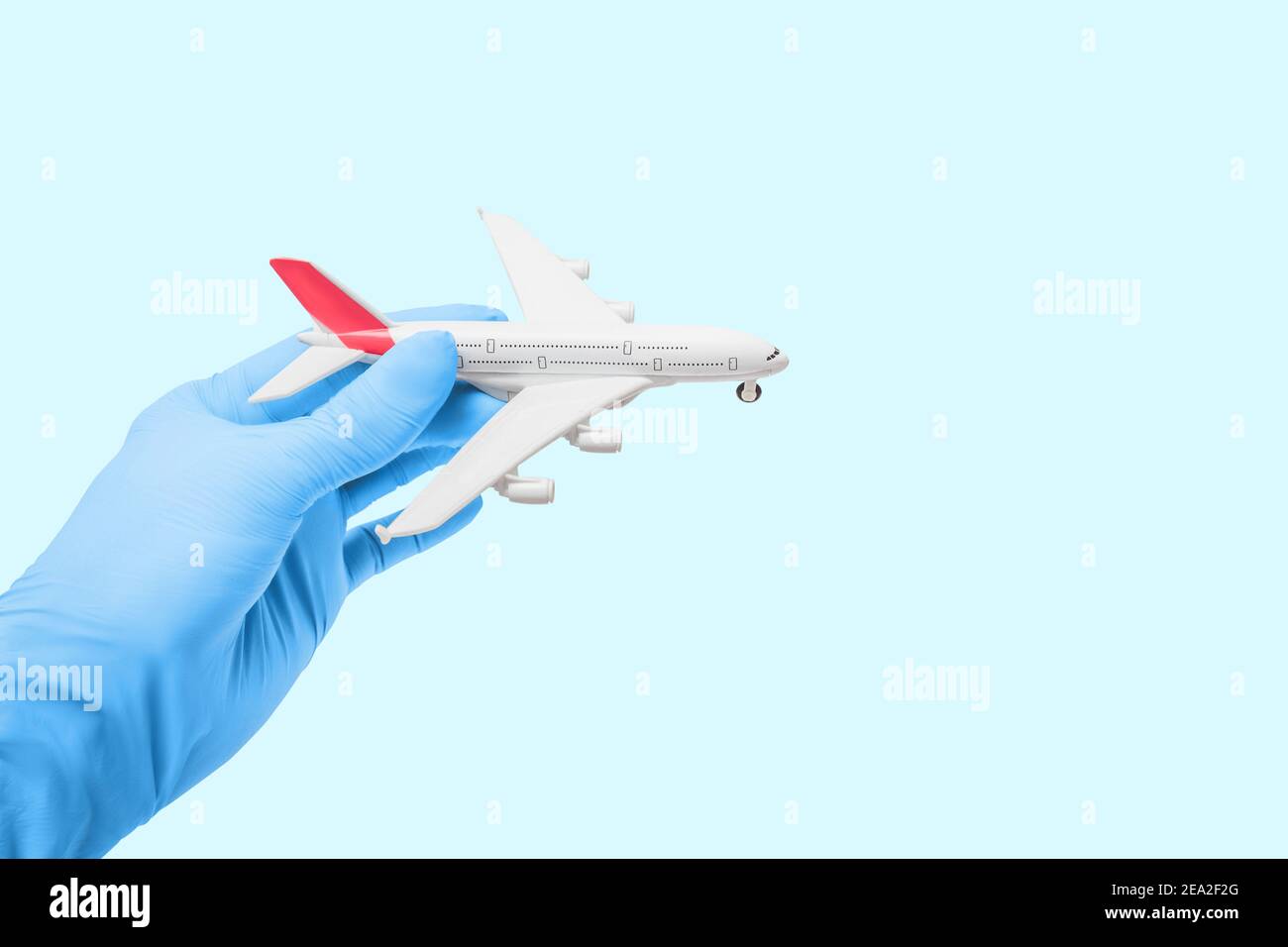 Doctor in medical gloves is holding a toy airplane. Concept of flight restriction and quarantine. Humanitarian assistance and emergency situation Stock Photo