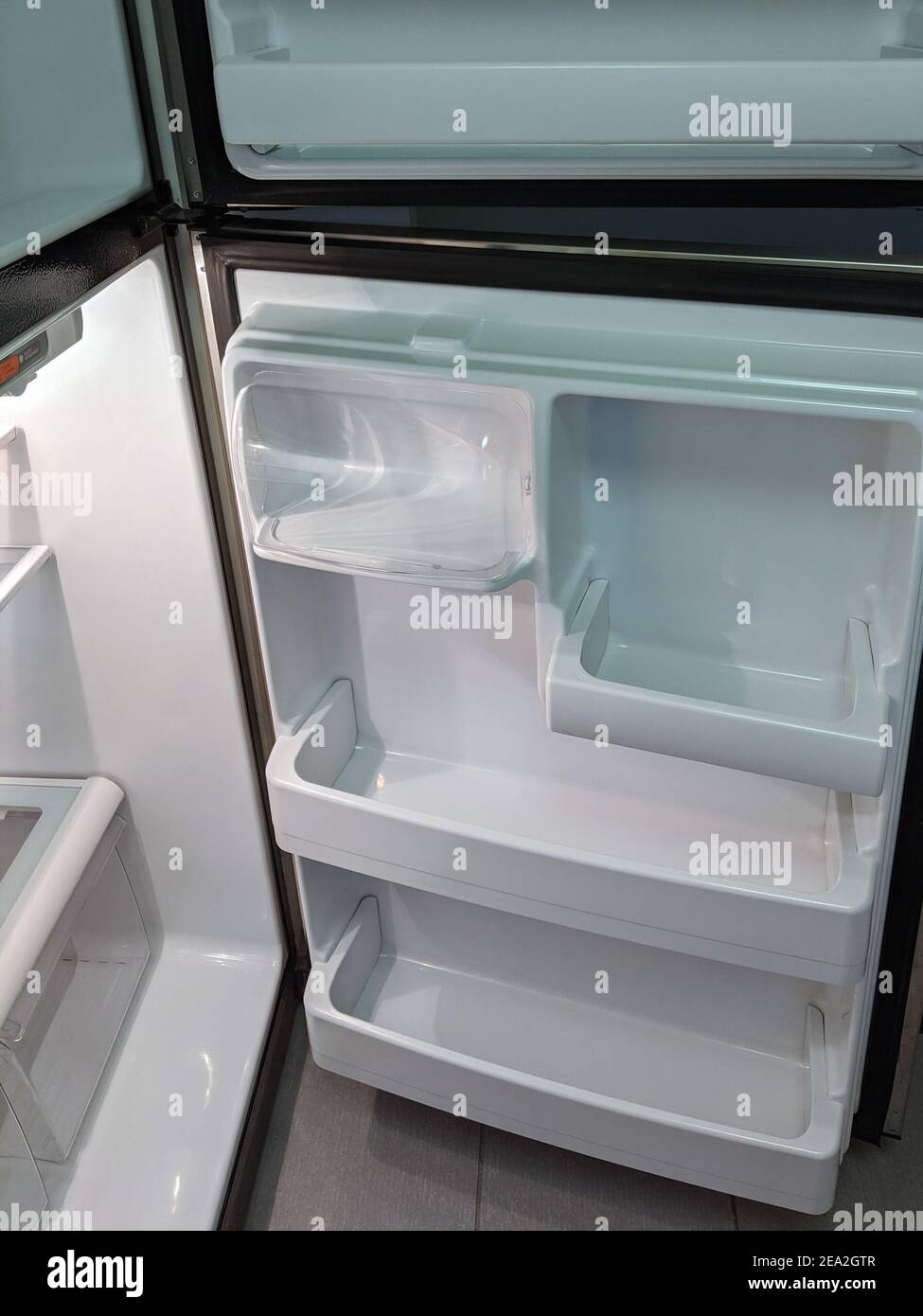 empty, modern refrigerator with opened doors. Inside of a clean fridge with plastic shelves Stock Photo