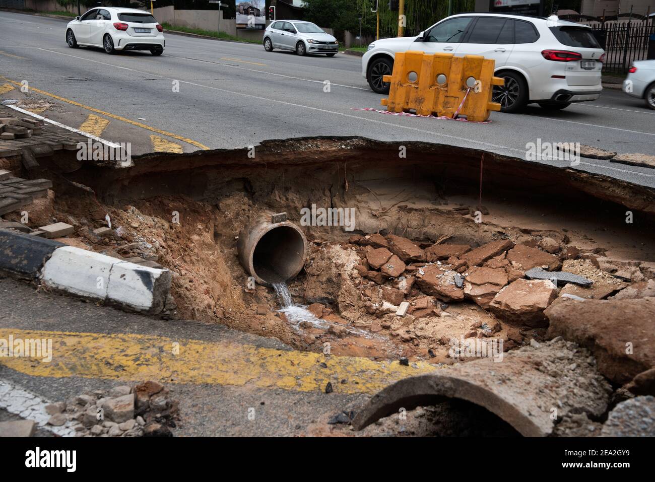 Large pothole and broken underground water pipe Stock Photo