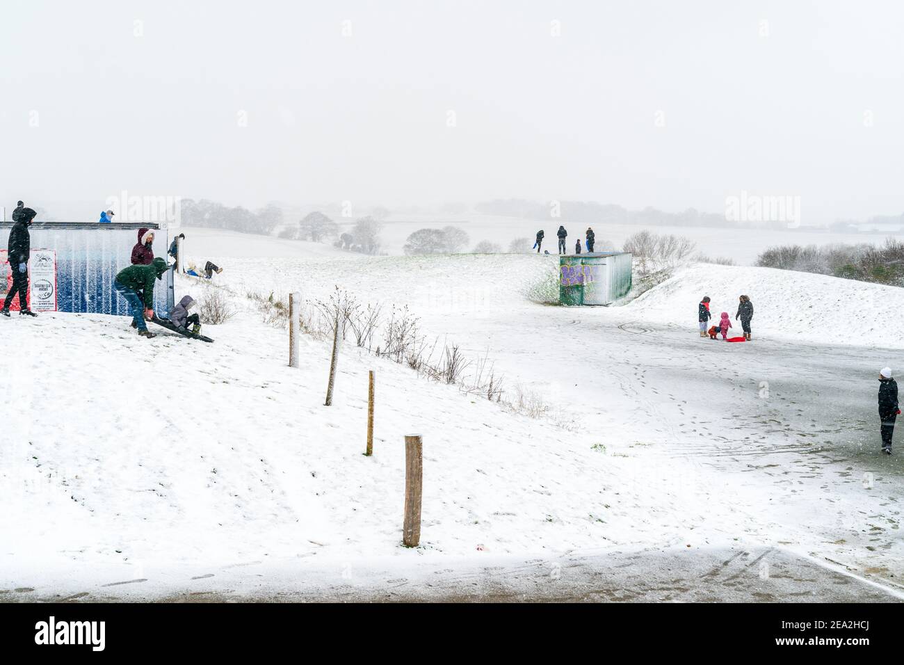 People And Families Out In The Snow During The February 21 Beast From The East 2 Snow Storm Snow Covered Small Hill With People Using Sledges To Ride Down The Hill Background Is