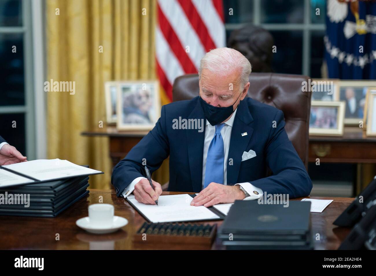 U.S President Joe Biden signs one of the 17 Executive Orders on Inauguration Day in the Oval Office of the White House January 20, 2021 in Washington, D.C. Stock Photo