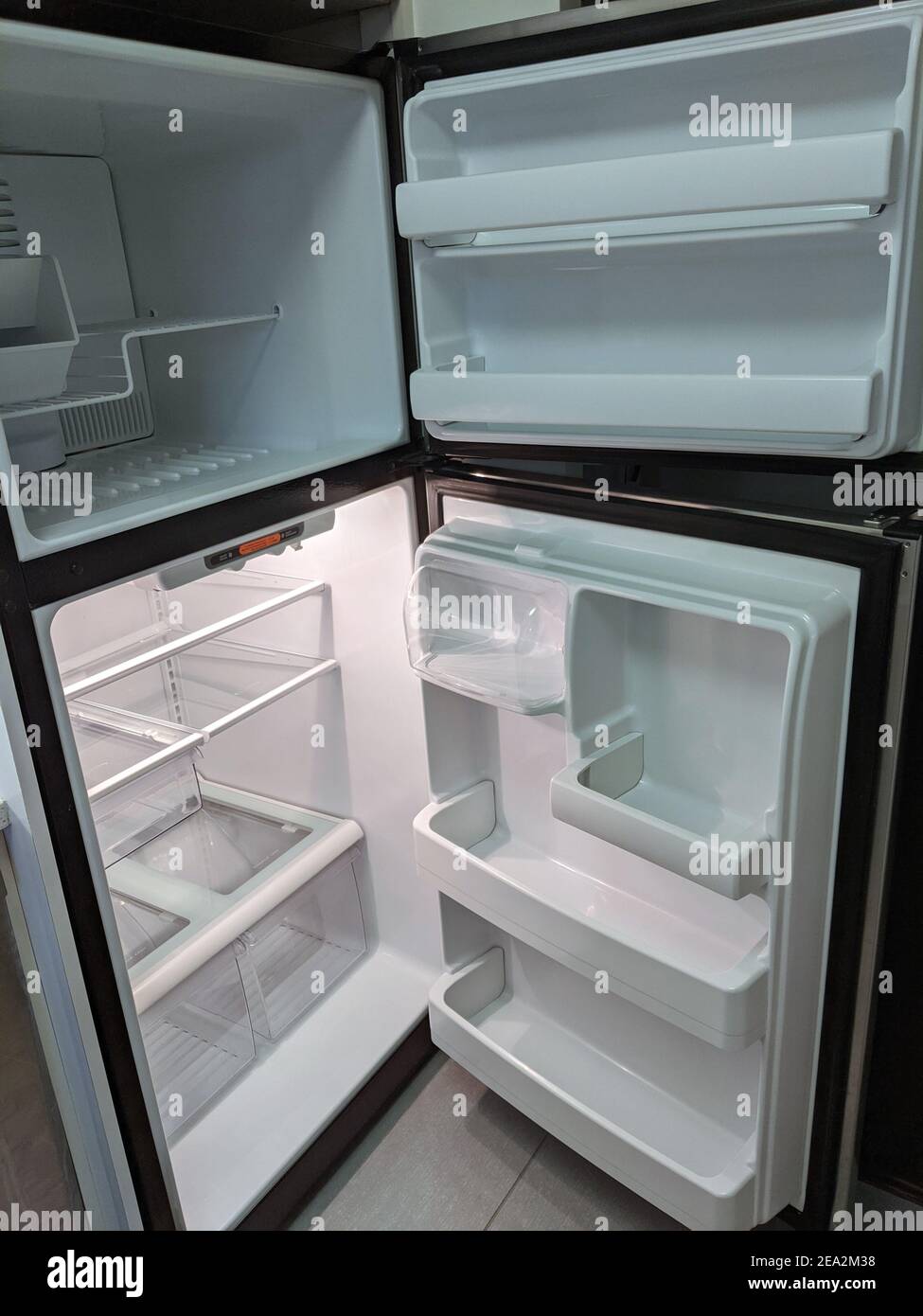 empty, modern refrigerator and freezer with opened doors. Inside of a clean fridge with plastic shelves Stock Photo