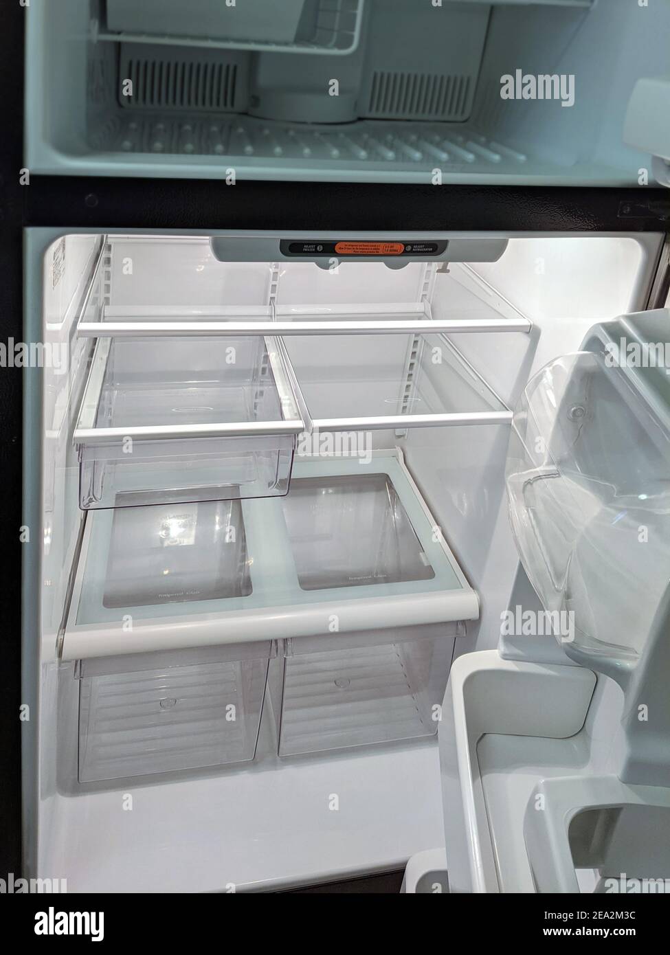 empty, modern refrigerator with opened doors. Inside of a clean fridge with plastic shelves Stock Photo