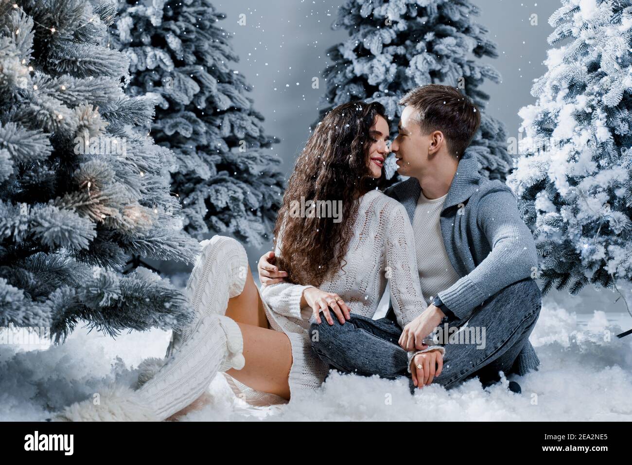 New year love story. Couple kiss and hug, snow is falling. Happy ...