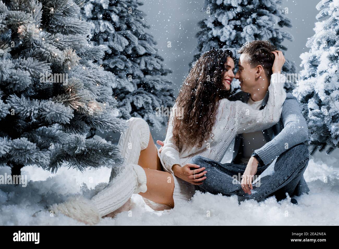 New year love story. Couple kiss and hug, snow is falling. Happy ...