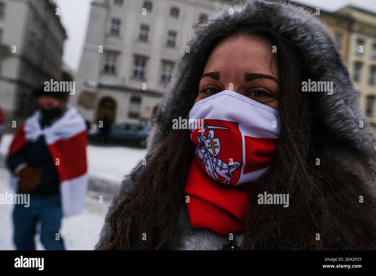A protester wears a face mask with the historical white-red-white flag of Belarus during a protest in solidarity with Belarus political prisoners at Krakow's Unesco Listed Main Square. Stock Photo