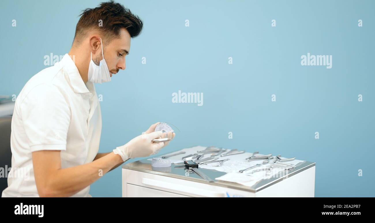 Dental technician working with a model of teeth and dental braces Stock ...