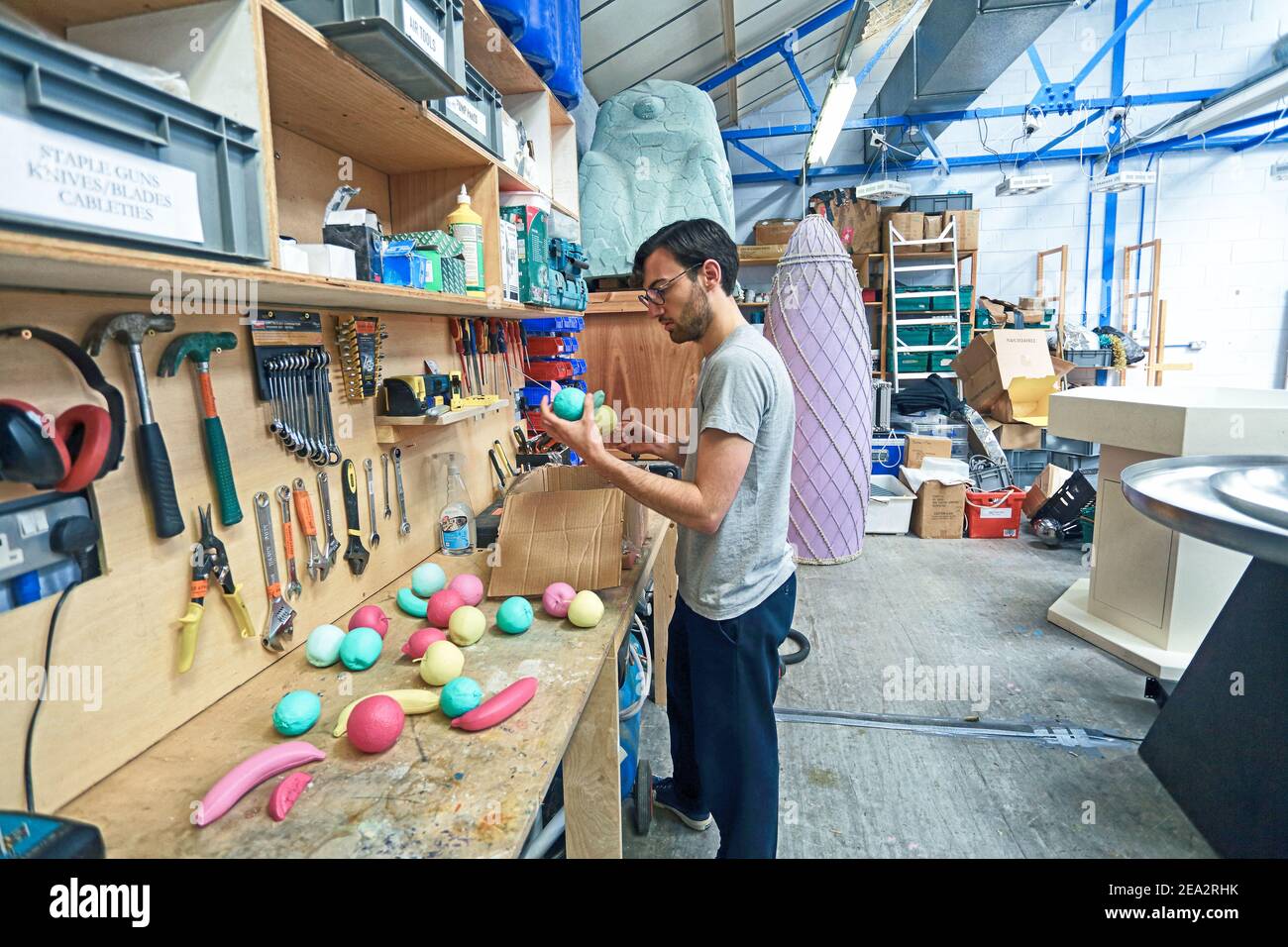 GREAT BRITAIN,London , Bombas and Paar , Set designer working in Studio painting plastic fruits . Stock Photo
